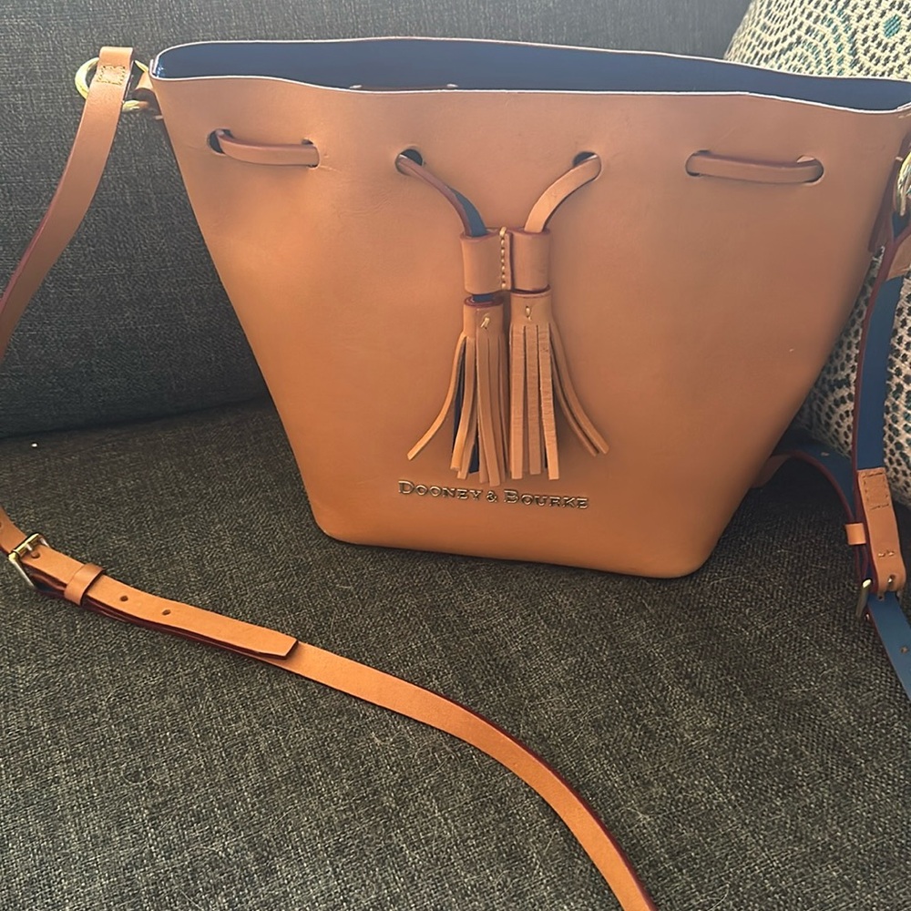 Dooney & Bourke Tan with colbolt blue inside. Change purse attached. Leather